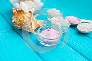 Sea Ã¢â¬â¹Ã¢â¬â¹salt in a glass white stones and Shell for spa and relaxation on a blue background